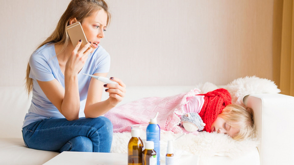 besorgte Mutter am Krankenbett des Kindes ruft bei Arzt an
