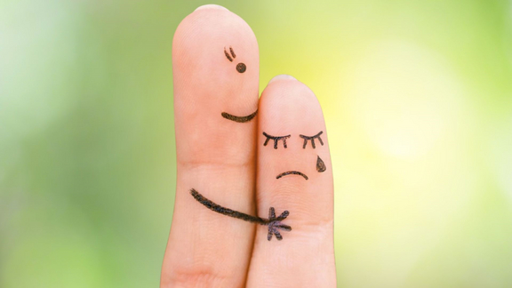 zwei Finger mit angemalten Gesichtern die sich Trost spenden