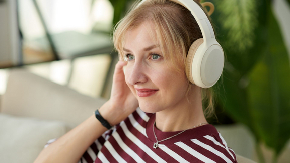 Frau mit Kopfhörern die Podcast hört