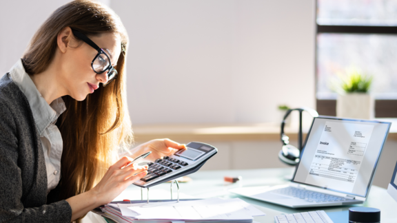 Frau bei Berechnung von Zahlen vor PC