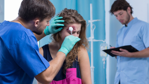 Mediziner beim versorgen einer Platzwunde am Kopf